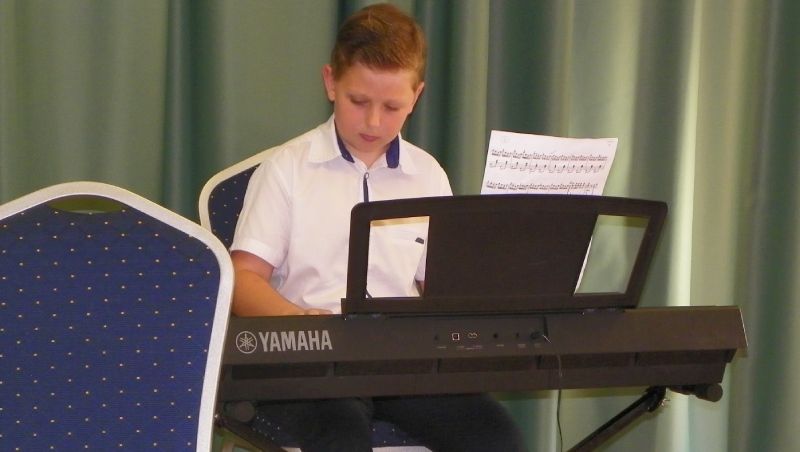 chłopiec grający na keyboardzie